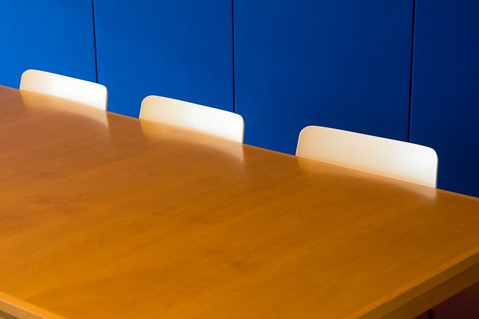 Een luxe houten vergadertafel in een stijlvolle kantooromgeving met comfortabele stoelen.